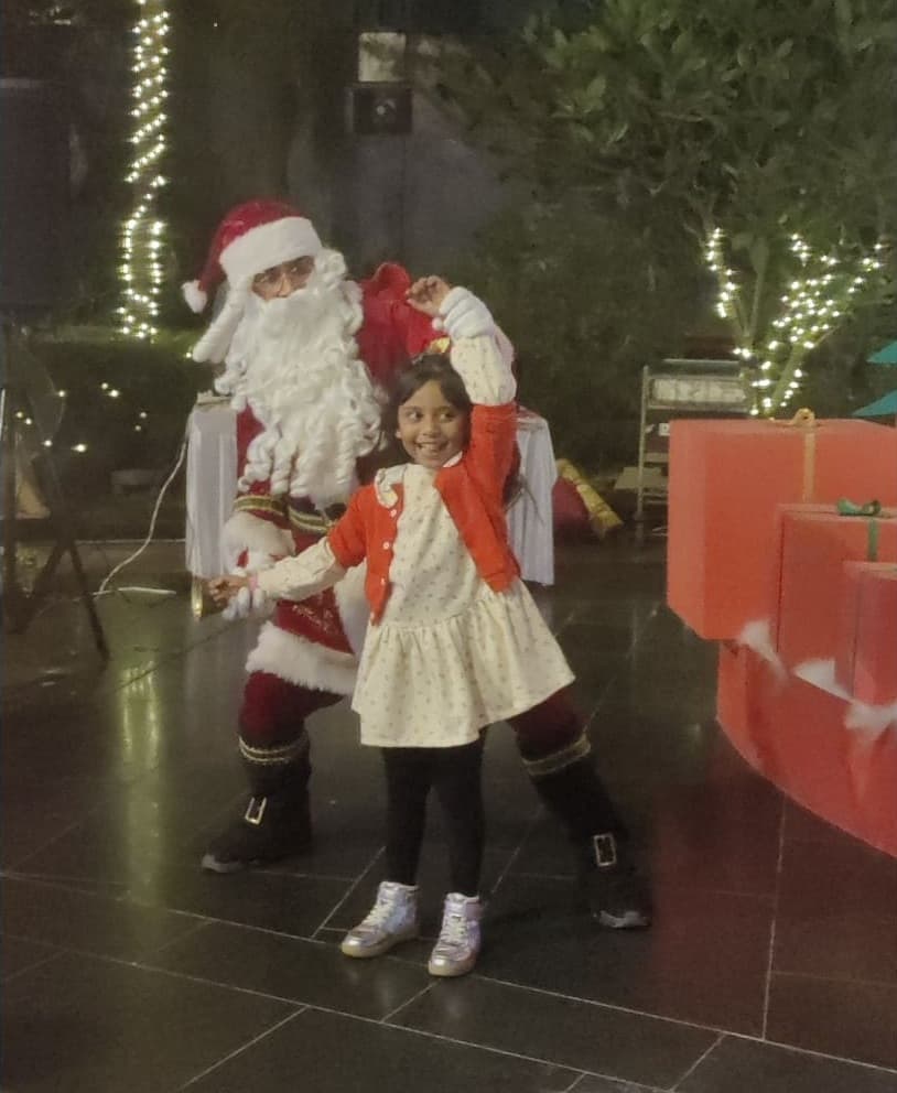 A senior citizen smiling as Santa bends to meet them